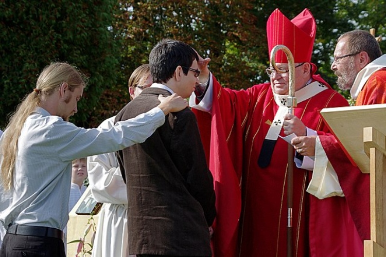 A Bishop seals a Confirmand with the Gifts of the Holy Spirit